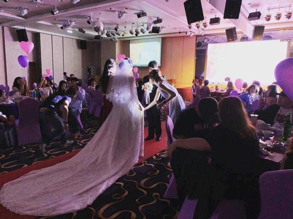 這張「婚禮」的照片是一個婚禮現場,新娘穿著白色的婚紗,新郎穿著西裝,他們正在舉行婚禮。