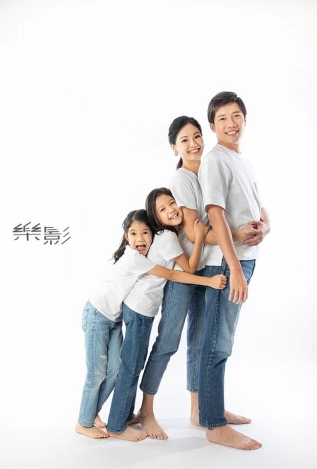 這張照片是一家人,他們穿著白色 T 恤和牛仔褲,依偎在一起,顯得非常溫馨和幸福。