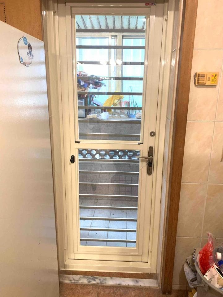 這張照片是一個房間裡的門,門上有鐵窗,看起來是為了安全而設。