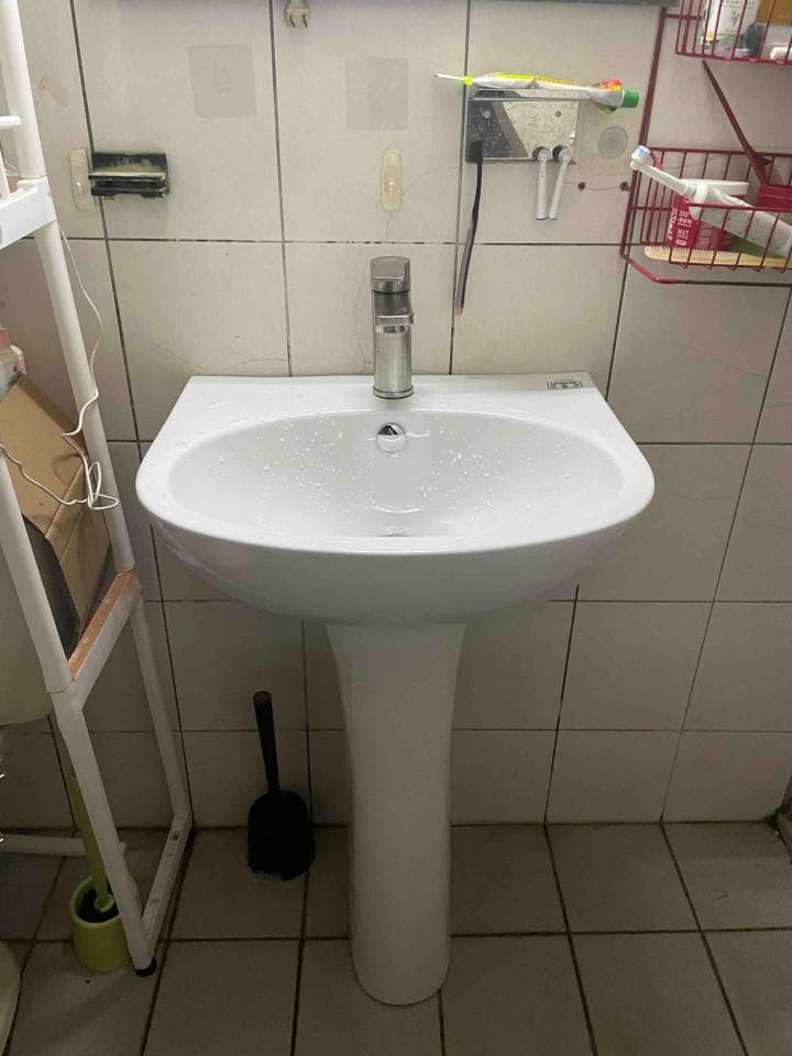 1) 照片顯示一個白色的洗手台,上面有一個銀色的水龍頭