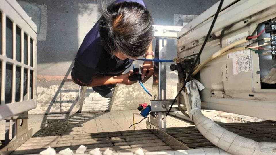 這張照片是一個修理冷氣的工程師,他正在檢查冷氣系統的管道。