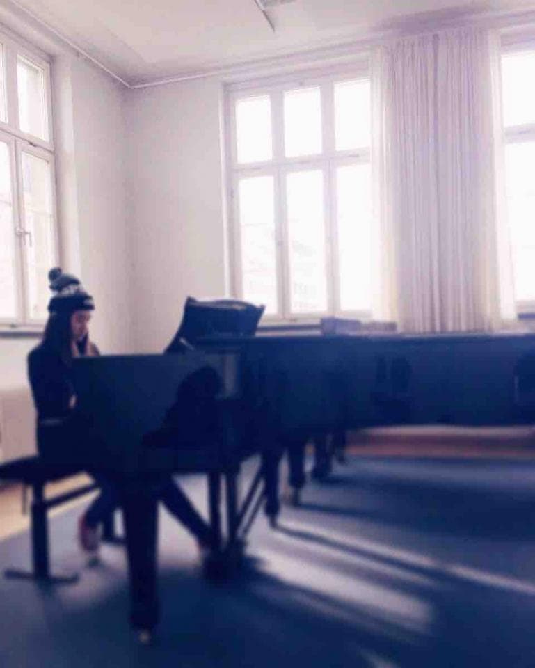 這張「鋼琴課」的照片是一個戴著帽子的女孩坐在鋼琴前,準備彈奏。